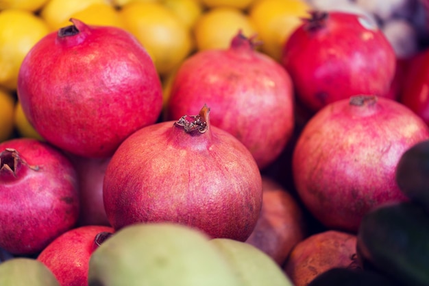 sale, harvest, food, fruits and agriculture concept - close up of pomegranate at street farmers market