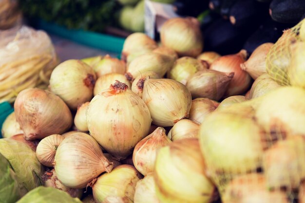 sale, harvest, food, vegetables and agriculture concept - close up of onion at street market