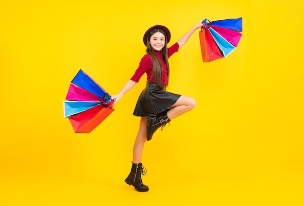 Sale and shopping concept Teen girl holding shopping bags isolated on studio background Run