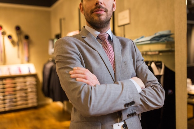 Photo sale, shopping, fashion, style and people concept - close up of man in suit and tie at clothing store