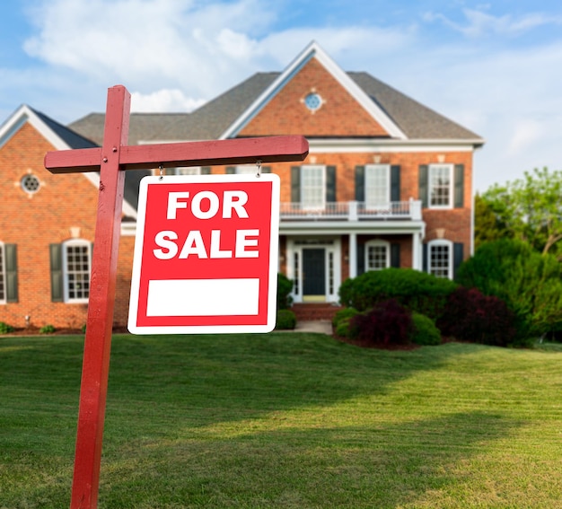 For sale sign in front of large USA home