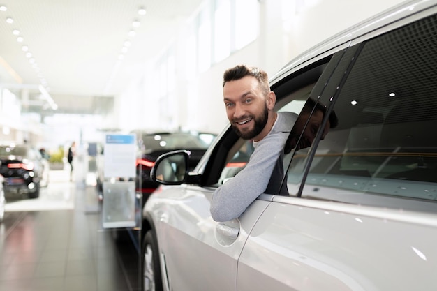 Sales manager in a car dealership hands over the keys and documents to the car