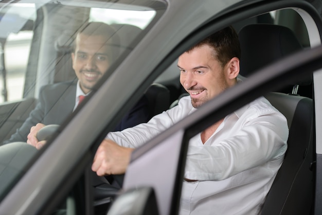 Salesman showing all the car for business person.