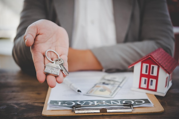 Salesperson Holding house keys concept, house keys for new house, new house purchase