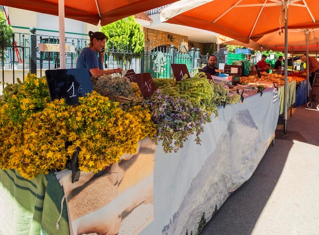 Saleswoman of mountain herbs and mountain tea in the Greek village market in Greece