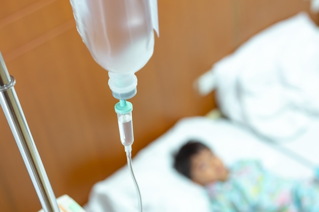 Saline intravenous (iv) drip in a children's patient hand, kid sick and sleep and equipment IV tube of Infusion pumps for patients in hospitals