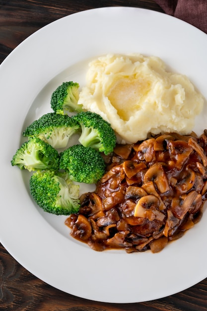 Salisbury steak with steamed broccoli and mashed potato