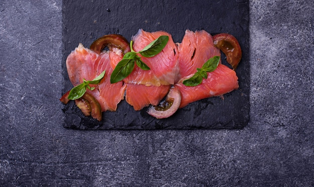 Salmon carpaccio with basil and tomato. Selective focus