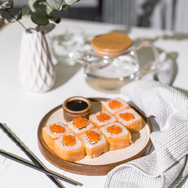 Salmon and caviar rolls served on a white plate