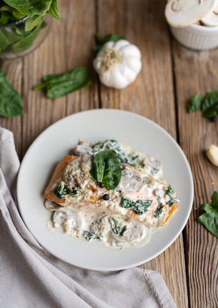 Salmon fillet by Florentine with creamy sauce on the top, mushrooms, garlic and spinach.