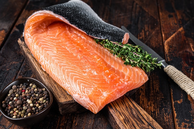 Salmon fillet fish on a  wooden board with herbs and salt