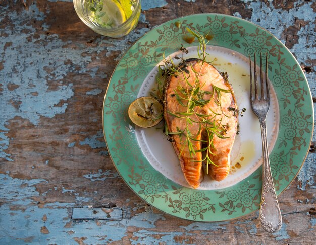 Salmon fish steak grilled with glass of water, supper. Healthy food. Top view