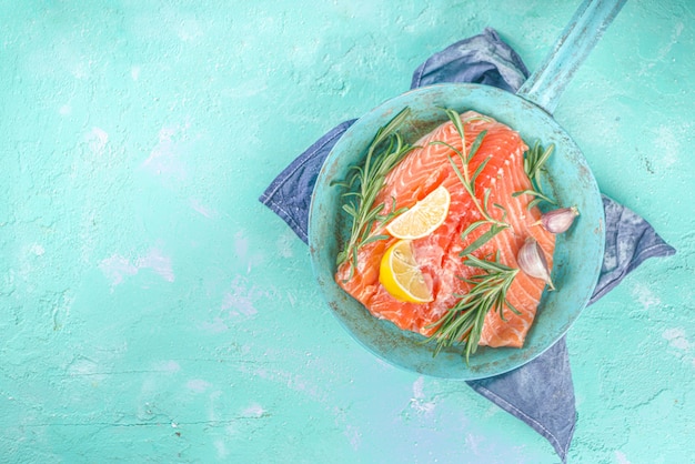 Salmon. Fresh raw salmon fish fillet with cooking ingredients, herbs and lemon in cooking pan