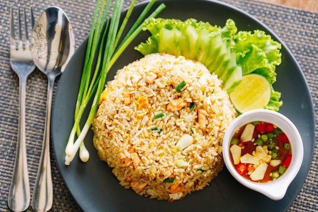 Photo salmon fried rice on a black plate on the dining table