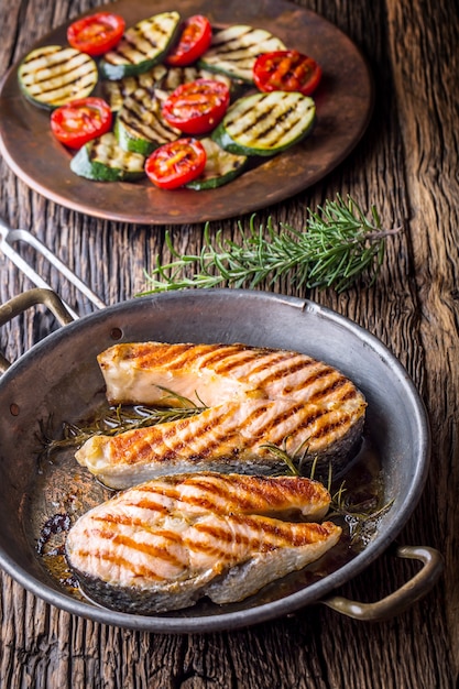 Salmon. Grilled fish salmon. Grilled  salmon steak in roasted pan on rustic wooden table.