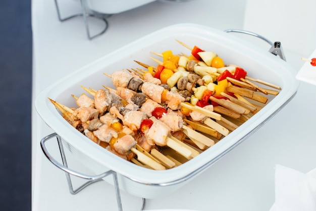 Salmon kebabs and mushrooms with vegetables on wooden skewers Katering