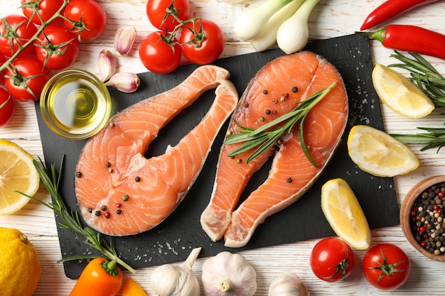 salmon meat and spices on wooden background