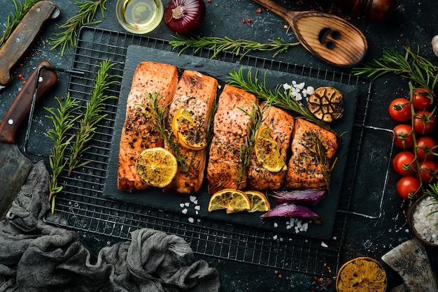 Salmon Pieces of grilled fish on a black stone background Recipe Seafood Free space for text