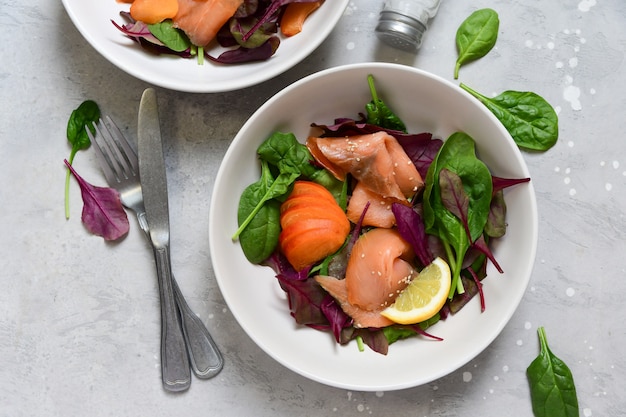 salmon salad spinach, arugula, sesame and lemon. dish for a healthy lunch or dinner. Top view