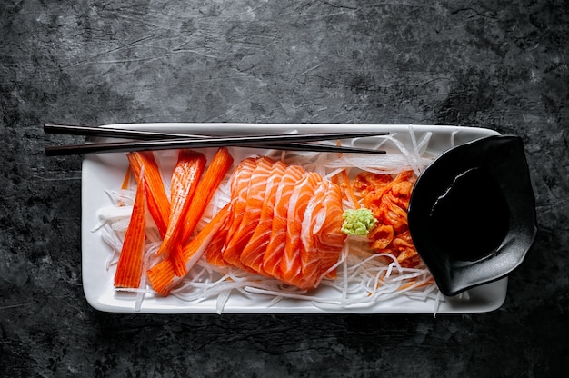 Salmon sashimi and imitation crab stick in Japanese style with kimchi, wasabi.