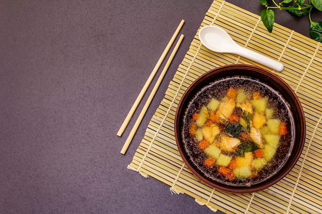 Salmon soup bowl with fresh greens. Traditional Asian hot dish