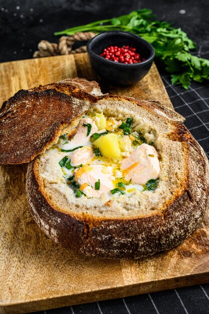 Salmon soup served in bread. Creamy hearty fish soup