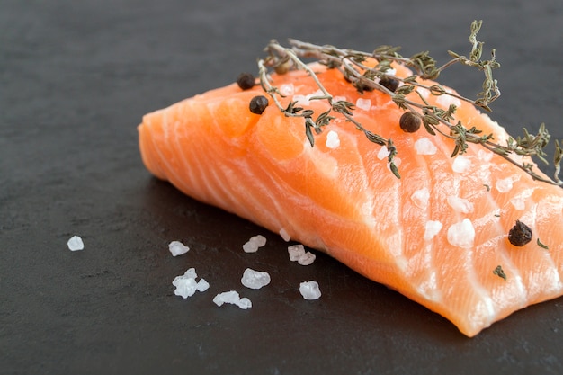 Salmon steak raw fish prepared for cooking. Top view on black table.