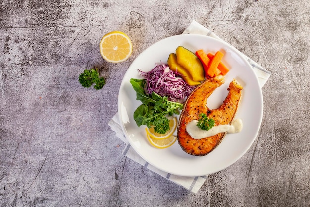 Salmon steak in white plate on table