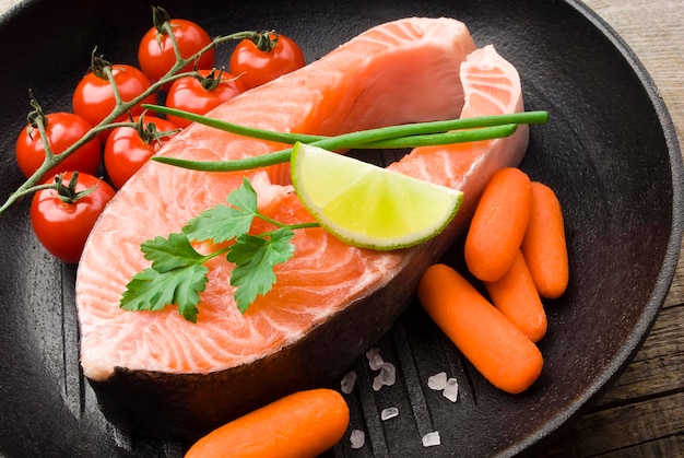 Salmon steak with vegetables on the pan