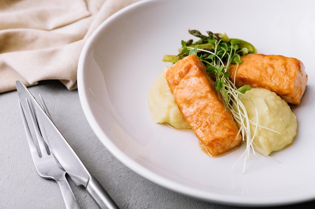 Salmon steaks with mashed potatoes on white plate