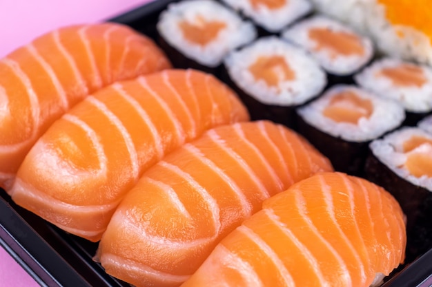 Salmon sushi and sashimi nigiri and maki roll closeup Delicious japanese food with fresh fish restaurant delivery set