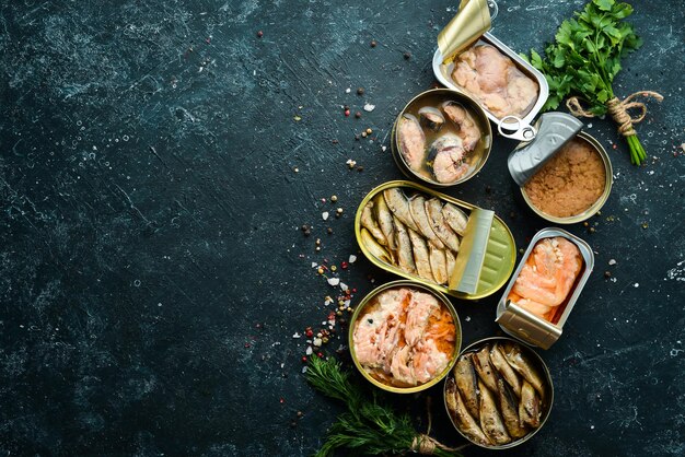 Photo salmon tuna mackerel and sprats  canned fish in tin cans top view free space for your text