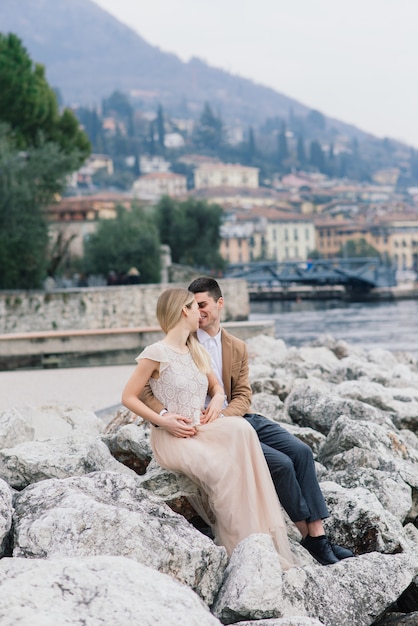 Salo, Italy. Romantic young couple sitting on the river dock