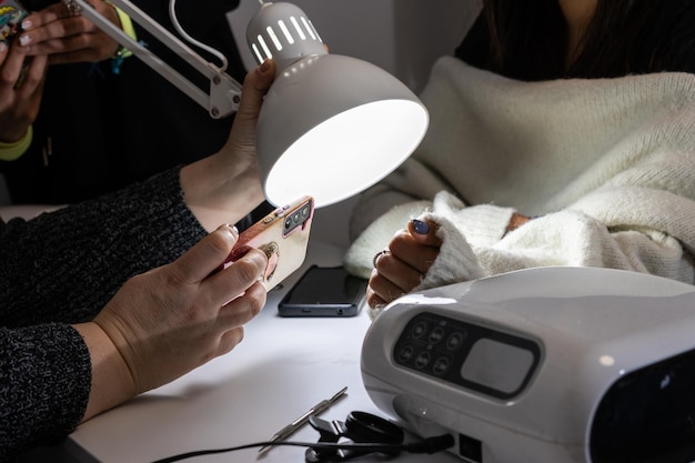 Salon customer capturing manicure with phone camera