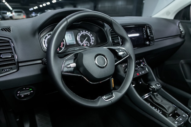 Salon of a new stylish car, steering wheel , dashboard with speedometer, tachometer and other setting buttons