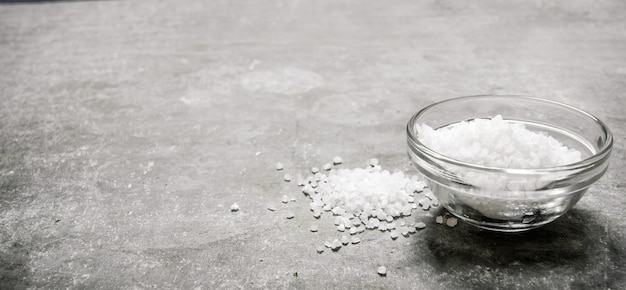 Salt in the Cup. On stone background.