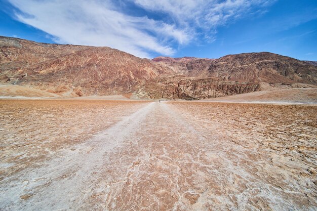 Salt flats path in desert leading to mountains of death valley