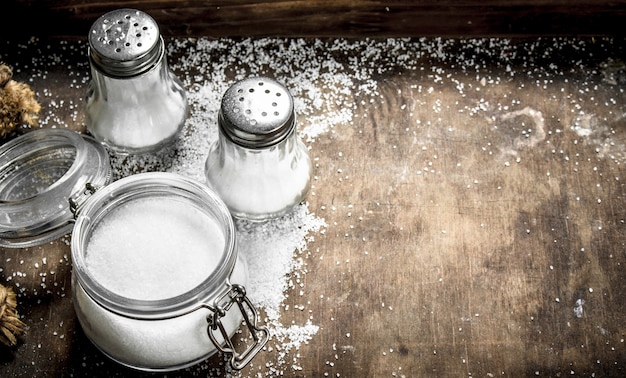 Salt in glass jar on a wooden table. On rustic table.