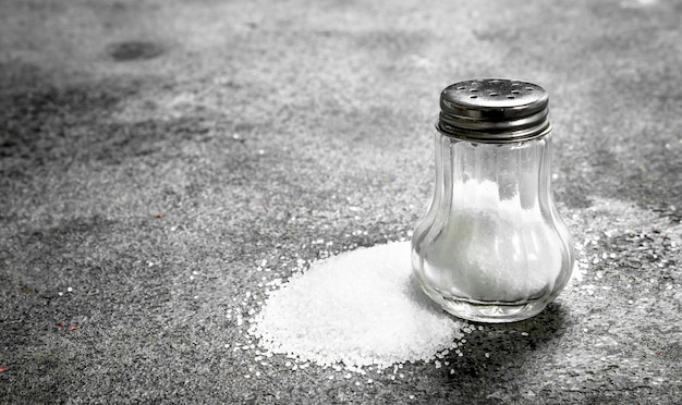 Salt in glass. On rustic table