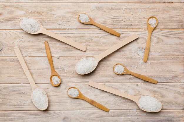 Salt on many wooden spoon on wood background Spoons with different salt