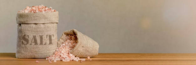 Salt price large crystals of pink himalayan salt closeup a coin in a pile of salt as a symbol of ris