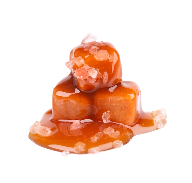 Salted caramel candies and sauce, isolated on white. Delicious caramel.