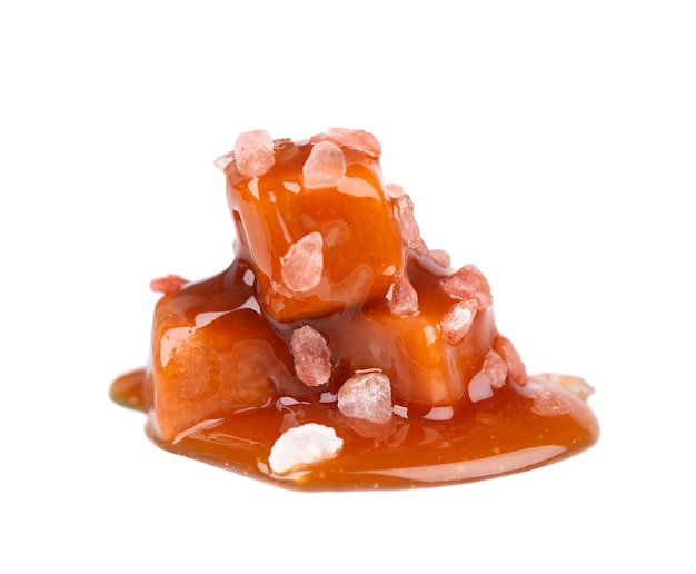 Salted caramel candies and sauce, isolated on white. Delicious caramel.