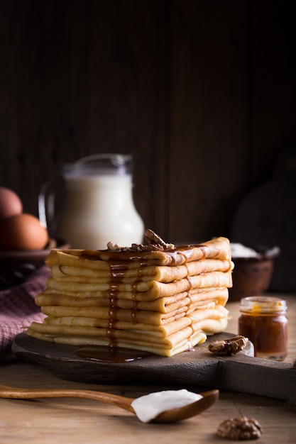 Salted caramel pouring on french crepes closeup view