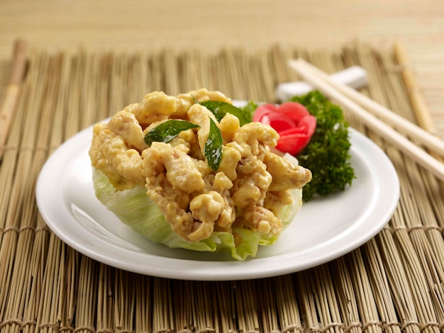 Salted Egg Chicken with chopsticks served in a dish isolated on table side view