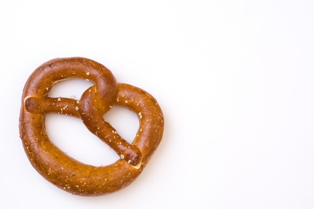 Salted pretzel isolated on white surface copy space