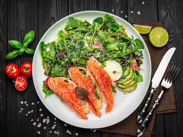 Salted salmon on croutons with fresh salad and parmesan cheese