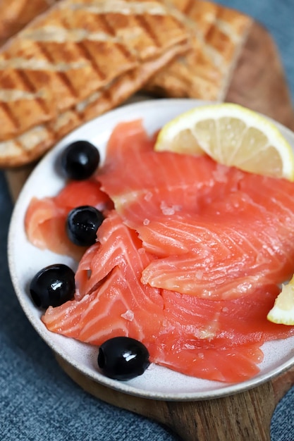 Salted salmon fillet with lemon and olives