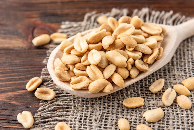 Salty peanuts on a wooden table