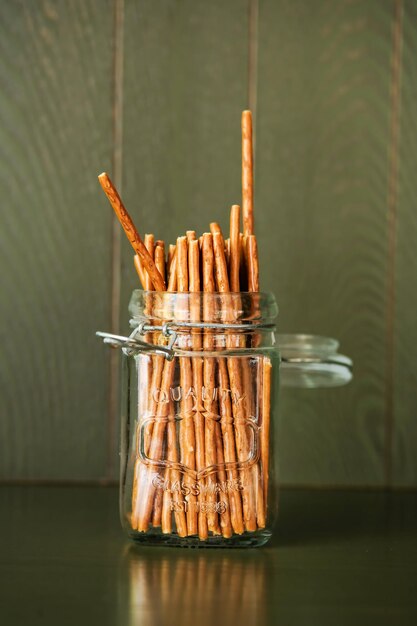 Salty pretzel sticks on a dark wooden table